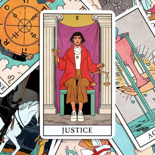 Justice tarot card on top of pile of Modern Witch tarot deck tarot cards